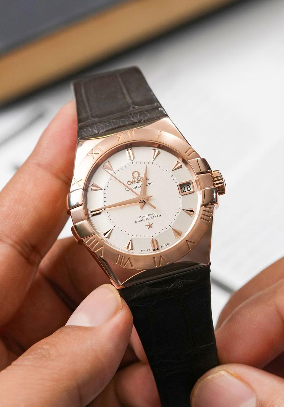 Omega’s Constellation has long been the maison’s signature of sensual elegance. The 38mm rose gold case retains the iconic claws gripping the bezel, while polished edges play with light against a refined brown alligator strap.