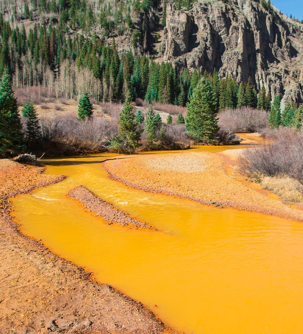 Yellow-orange toxic waste in water on the mountain in Colorado, USA